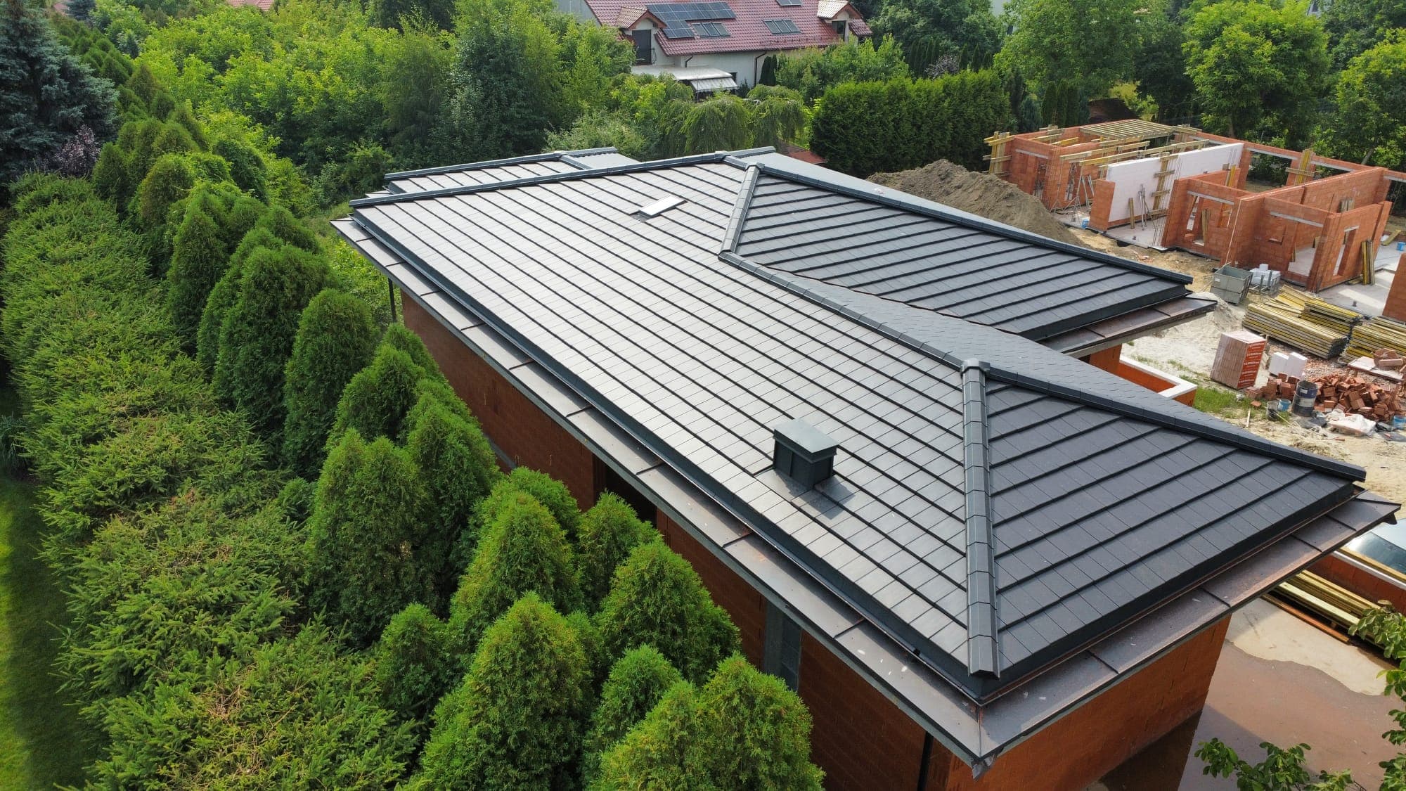 Dachówka płaska na dachu domu — widok z drona w otoczeniu zieleni