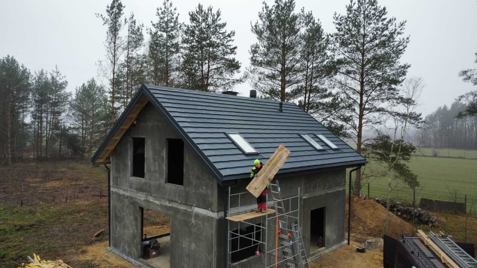 Montaż dachówki płaskiej na domu jednorodzinnym z oknami dachowymi