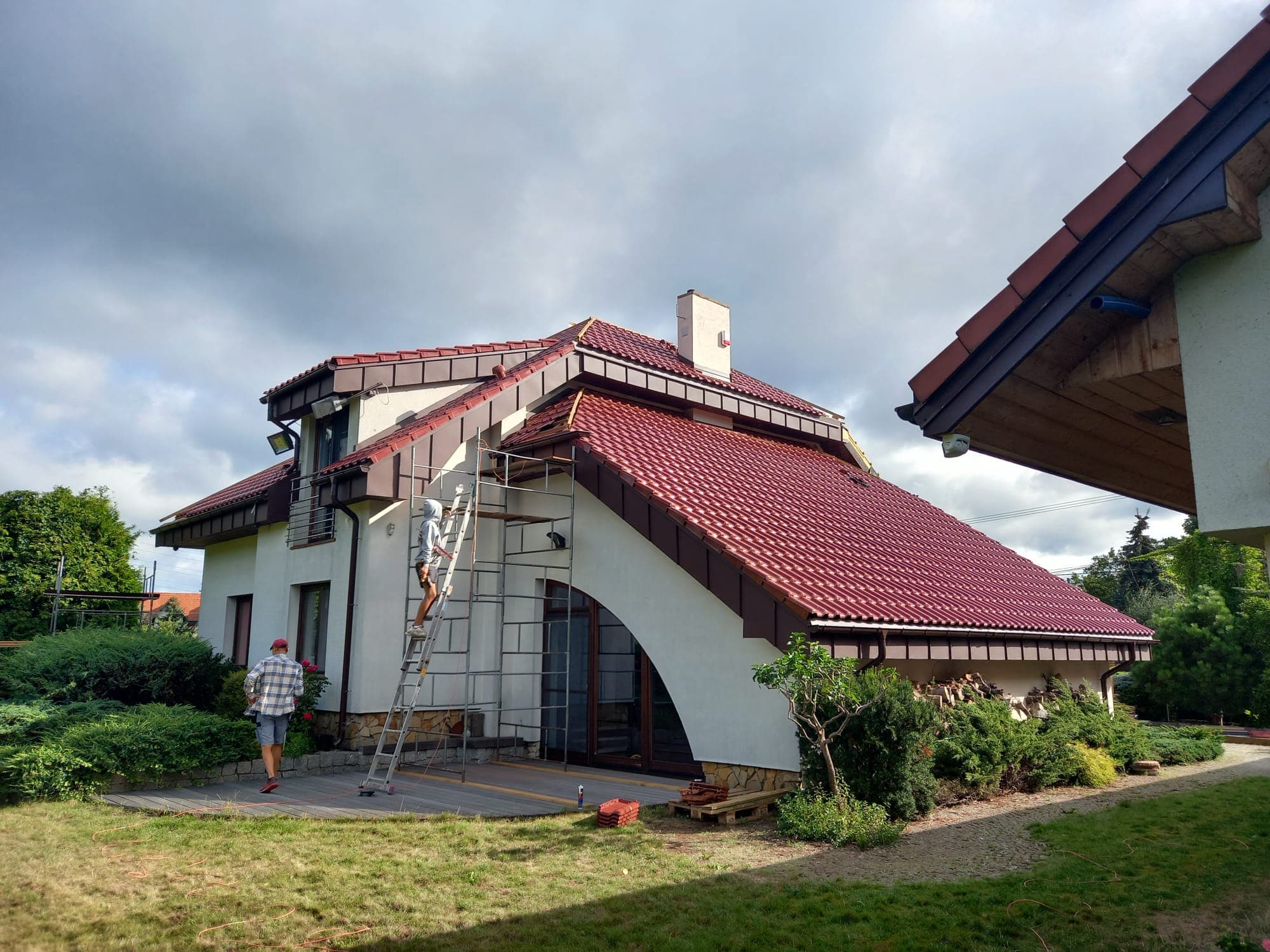 Naprawa dachu z czerwoną dachówką ceramiczną — rusztowanie