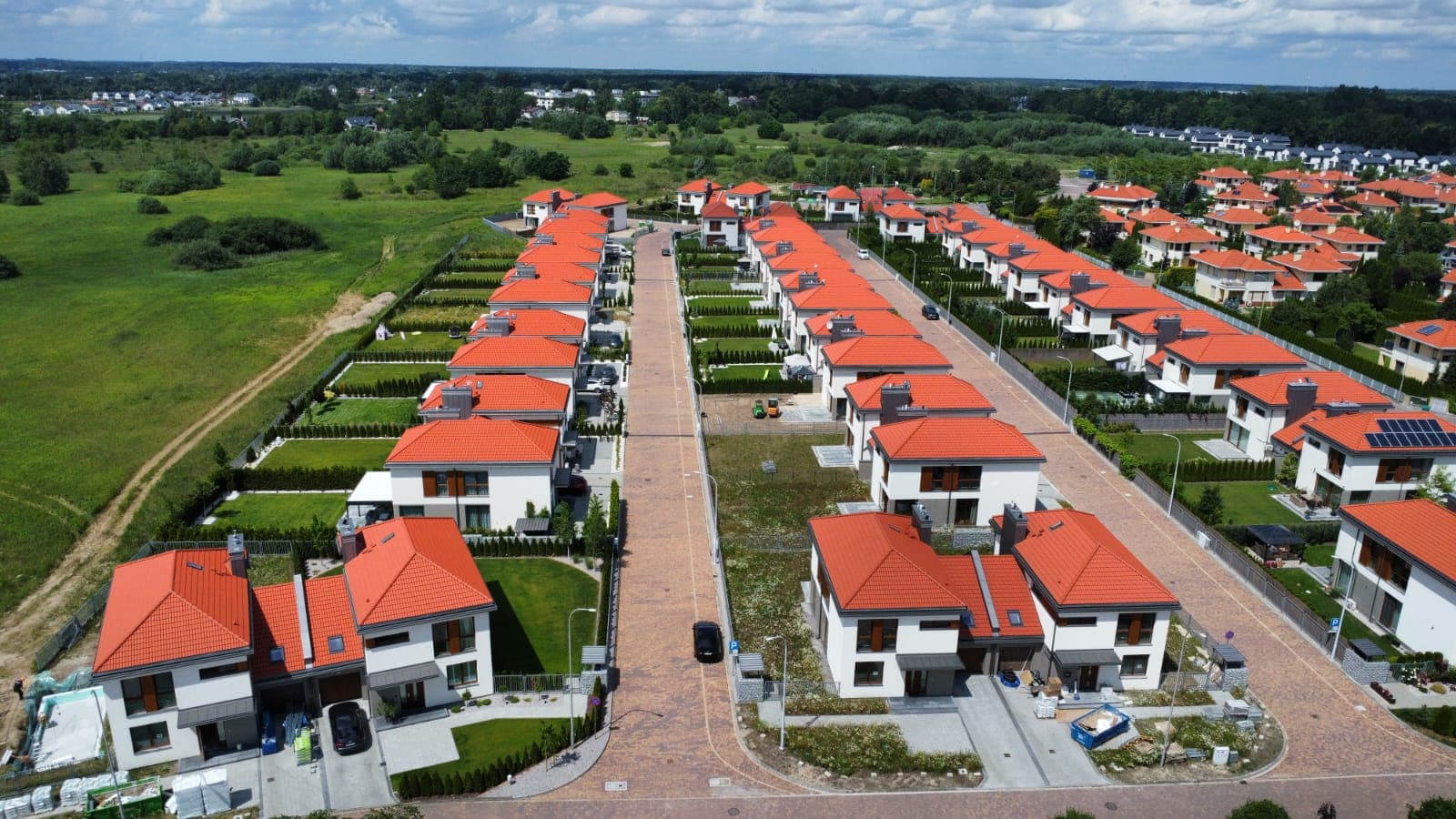 Osiedle domów z czerwoną dachówką ceramiczną — widok z drona