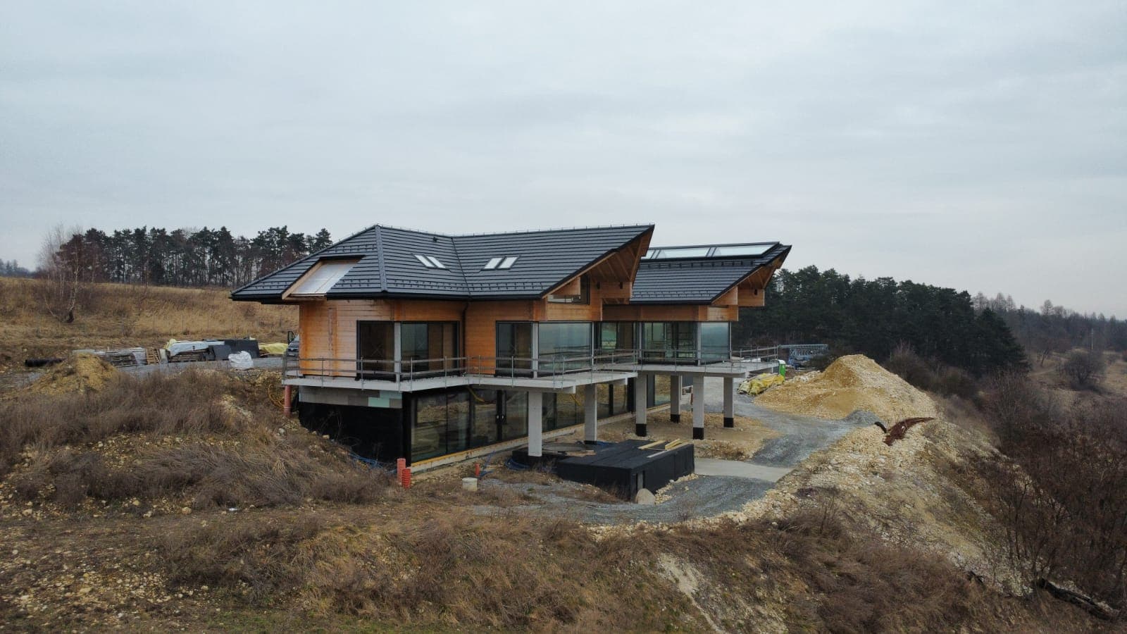 Nowoczesna rezydencja z dachówką i drewnianymi akcentami na wzgórzu